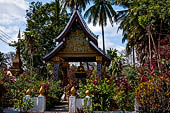 Wat Xieng Thong temple in Luang Prabang, Laos. The small pavilion with a seated Buddha statue. 